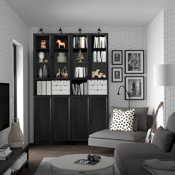 Large modern living room with monochrome BILLY bookcases, grey sofa, round coffee table, guitar, and black and white wallpaper.