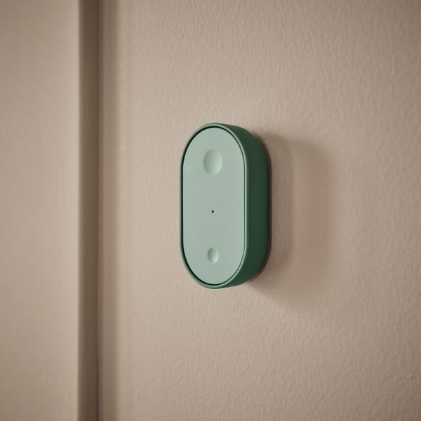 Mint green smart remote control on wall.