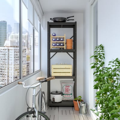 Black BROR shelving unit stores kitchen items near window. Holds pots, pans, and plants. Tall, sturdy, fits small space.