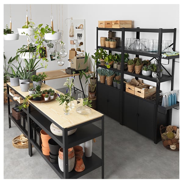 Black BROR storage units with wooden shelves, housing plants and garden supplies.