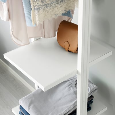 White ELVARLI shelf holding brown purse, folded clothing, and hanging garments.