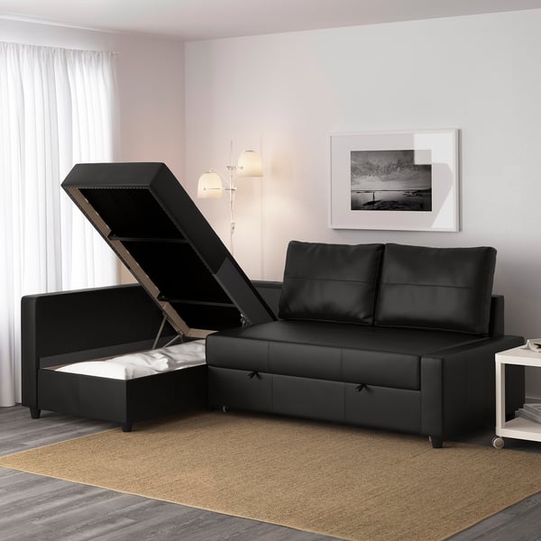 Black convertible sofa with open storage compartment, showcasing integrated bedding storage.