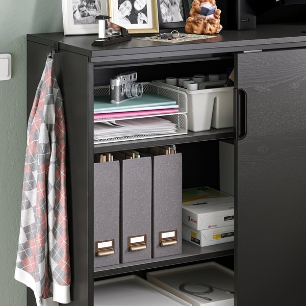 Black GALANT storage cabinet with adjustable shelves, holding documents, office supplies, and accessories.