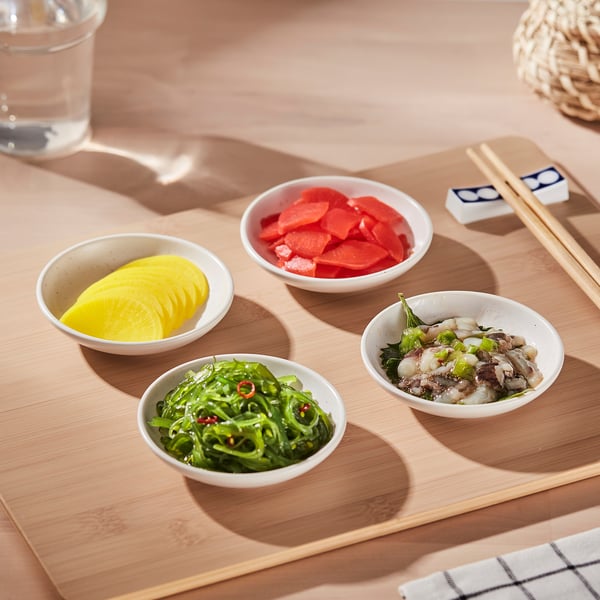 Small bowls on bamboo tray: miso soup, pickles, veggies, plus chopsticks.