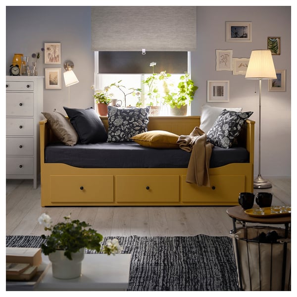 Yellow HEMNES day-bed with drawers, mattress, pillows, lamp & artwork.