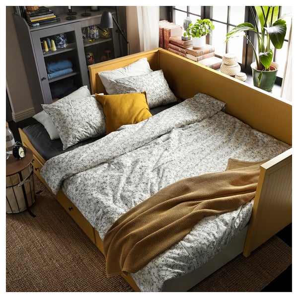 Cosy yellow day-bed with storage, perfect for compact spaces, featuring two large drawers, soft pillows, and natural wood design.