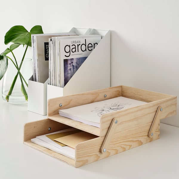 Wooden letter trays holding papers and magazines, light beige, with a small plant in a glass vase nearby.