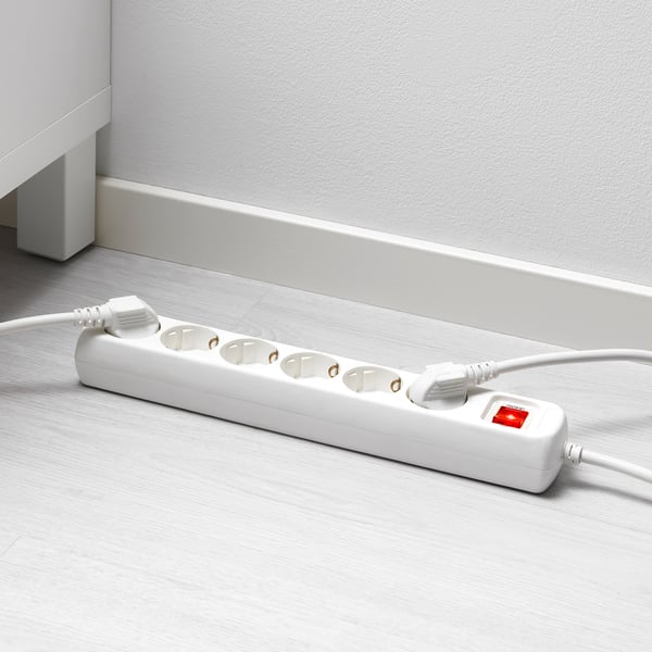 White surge protector with 6 outlets on wood floor.
