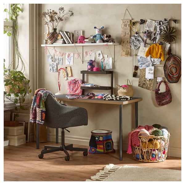 Creative home office setup featuring LAGKAPTEN black desk with grey chair, colourful yarn, and handcrafted decor.