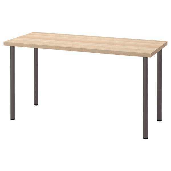 A wooden desk, LAGKAPTEN, with a light honeycomb top and black metal legs, standing on four adjustable feet for stability.