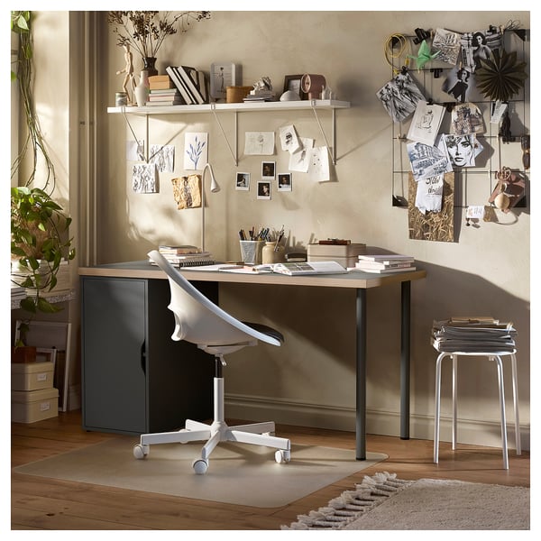 A beige home office setup with a LAGKAPTEN desk, sleek chair, and shelves. A light wood top, white metal legs, and wheel casters.