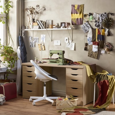 A home office with LAGKAPTEN desk, ergonomic chair, vintage sewing machine, and mood boards.