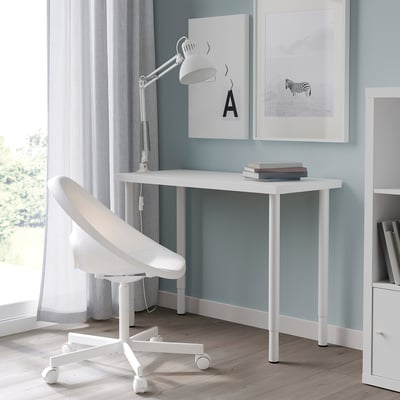Modern white study setup. Desk LINNMON adjustable legs. Paired with a white chair and lamp. Light grey wall art.