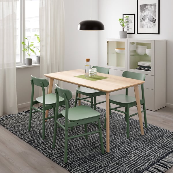 Simple modern dining set with light wood table and green chairs, perfect for small spaces.