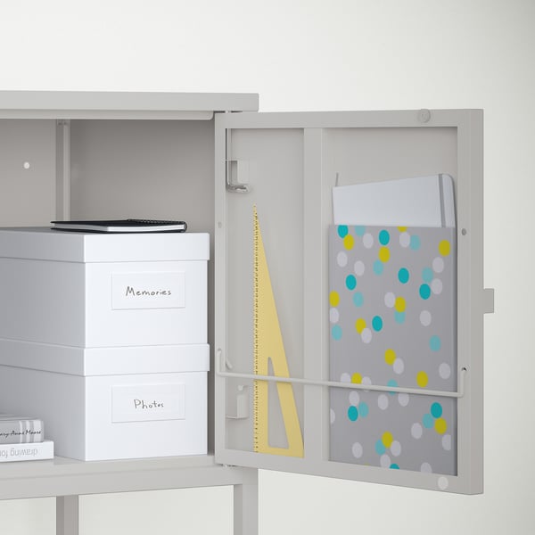 Organised cabinet with open door, shelf with laptop and file folders, boxes labelled memories and photos,