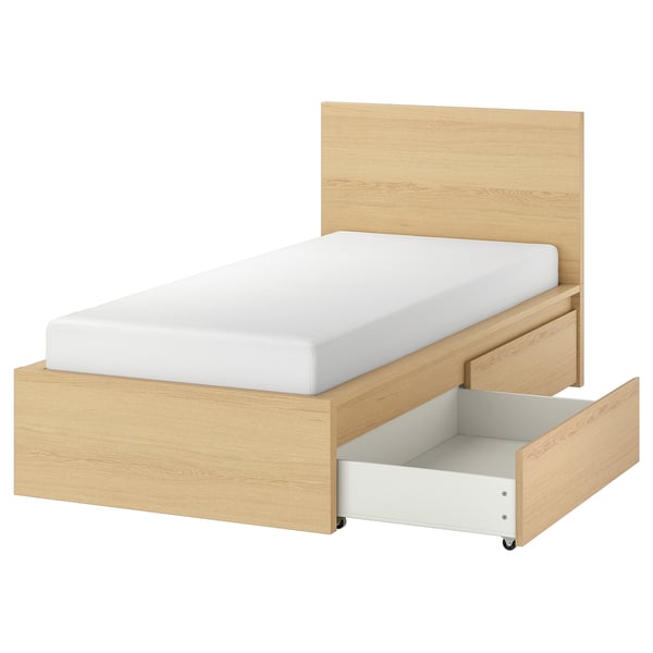 The MALM bed a light oak finish, with a white mattress and open storage drawer. Modern and minimalist design.