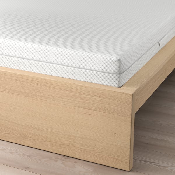 Wooden bed frame with adjustable slats and high headboard, displaying mattress support and comfort.