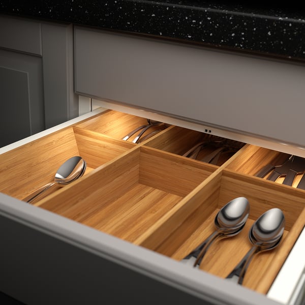 Wooden drawer organiser with built-in led lights for utensils, illuminating contents automatically.