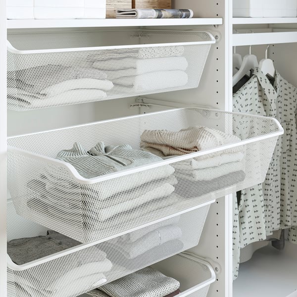 White mesh basket in closet for folded clothes, with additional compartments, part of PAX system.