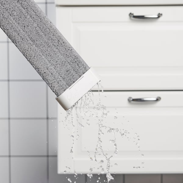 Water flowing from a grey tap into a white sink, demonstrating a cleaning mops use.