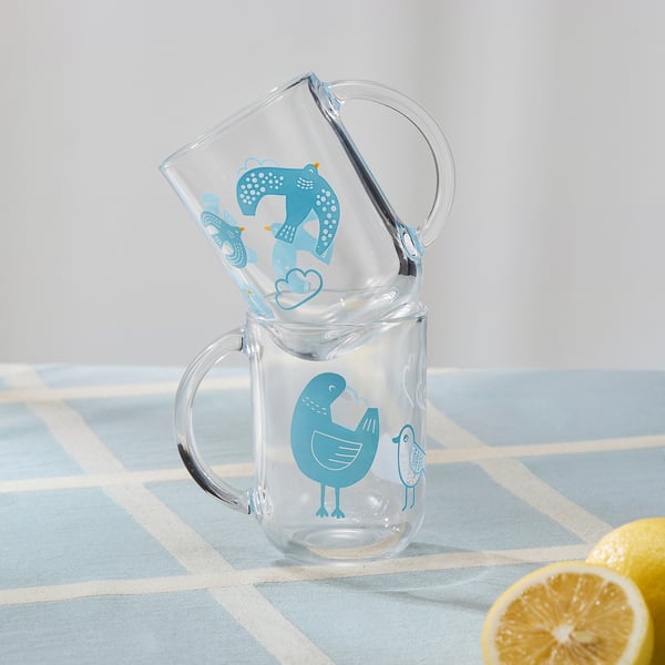 Two glass mugs with blue bird designs are stacked neatly. The top mug has a comfortable handle and is clear, perfect for various beverages.