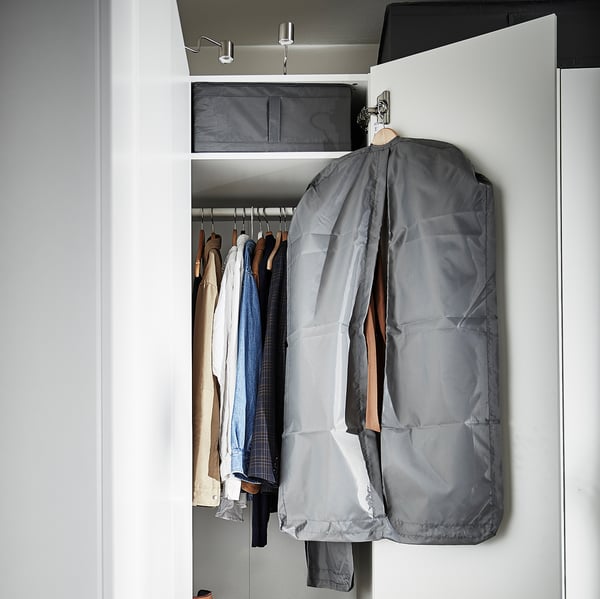 Open closet with clothes in grey SKUBB bag and other hangers.