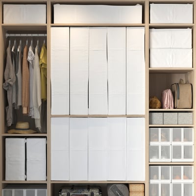 Organised closet with SKUBB boxes, clothes, and bags. White boxes store seasonal items, lining shelves with clear and fabric boxes for smaller items.