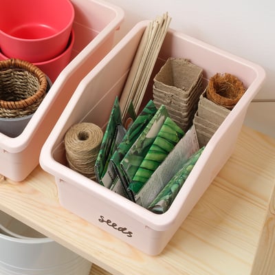 Pink seed box with gardening supplies.
