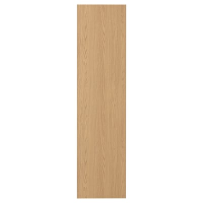 A narrow, light brown STORKLINTA wooden door in an oak finish, rectangular and vertically oriented, with a smooth, minimalist design.