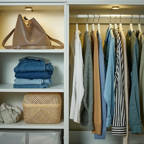 Organised closet: jeans, handbag, baskets left; clothes right.