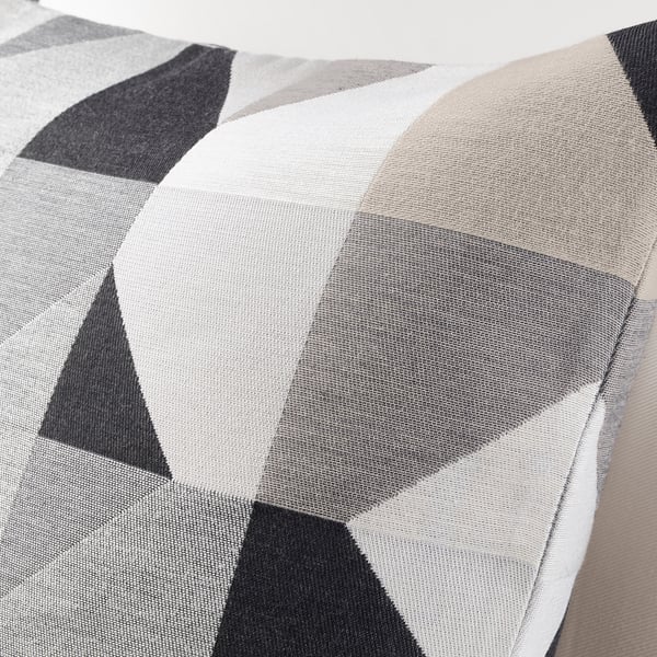 Geometric cushion with intricate weave, featuring black and white triangles. Subtle texture, zip detail.
