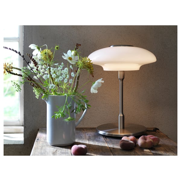 Cosy lamp with TÄLLBYN shade, blue vase with flowers and peaches.
