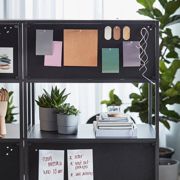 Black TROTTEN double-sided office cabinet with locked and open storage, featuring a mounted whiteboard and notice board.