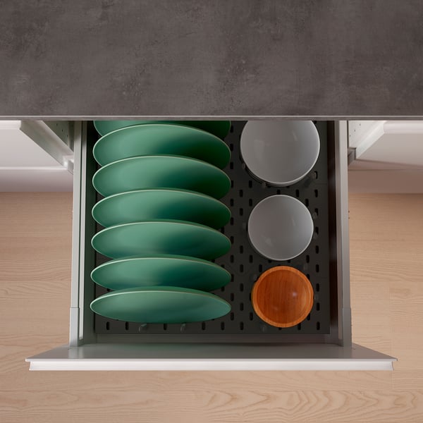 Organised kitchen drawer with green plates and bowls, using updatera pegs for storage.
