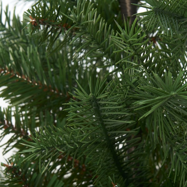 Close-up of lush green pine needles from a high-quality artificial christmas tree, showcasing detailed textures and vibrant colour.