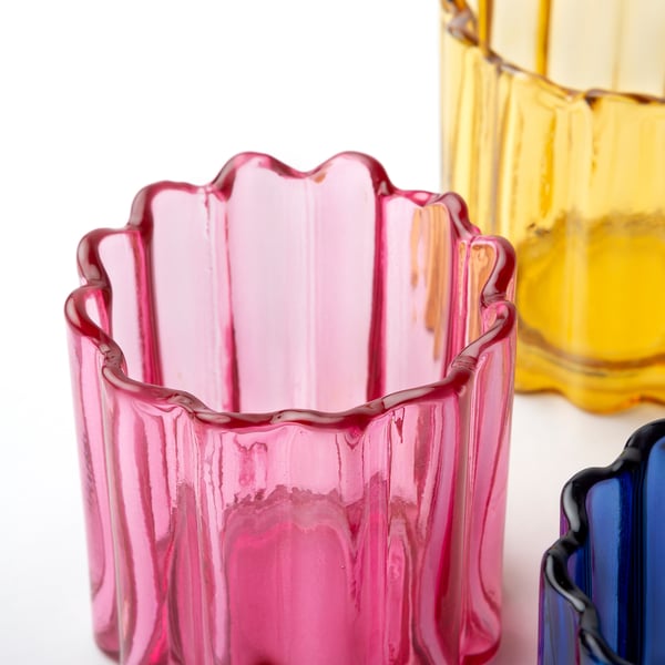 Hand-crafted, colourful glass tealight holders display intricate design and smooth, organic shape, perfect for adding a festive touch to any setting.