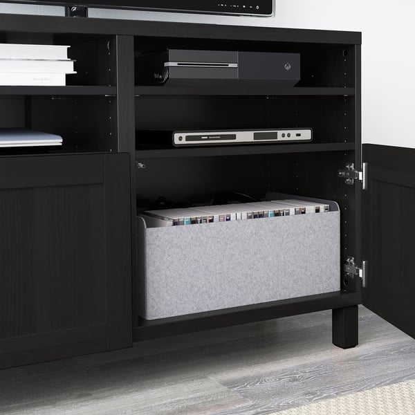Black BESTÅ tv bench with adjustable shelves, cable management, and a grey organiser bin.