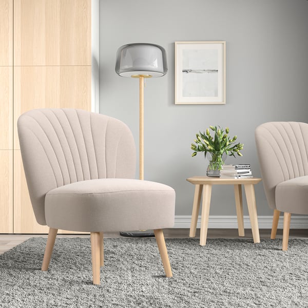 Neutral setting with BILLHAMN chair, grey, wooden legs, back support, side table, lamp, identical chair behind.
