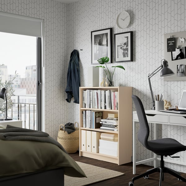 Modern bedroom with BILLY bookcase, desk, & balcony, geometric wallpaper.