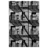 Black and white multiple fire escapes on the side of an urban building.