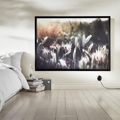 Bedroom with nature photo, books, and minimalist decor.