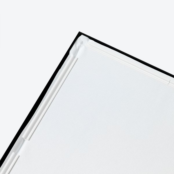 Close-up of BJÖRKSTA framed picture edge: sleek black frame, crisp white canvas, sturdy construction.