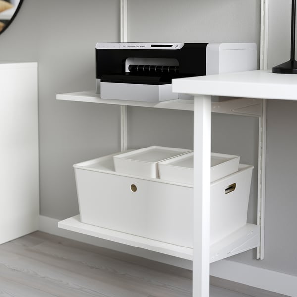 White wall-mounted shelves with storage boxes and a printer. Part of the BOAXEL system for efficient organisation.