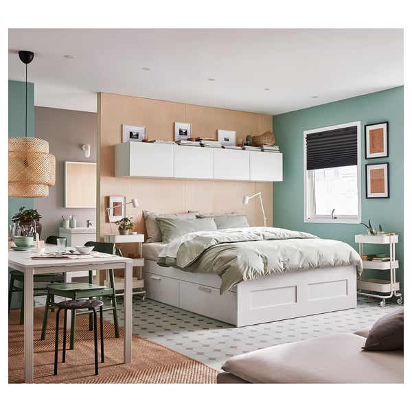 Modern bedroom with BRIMNES bed, storage, white comforter, dining table, and chairs.