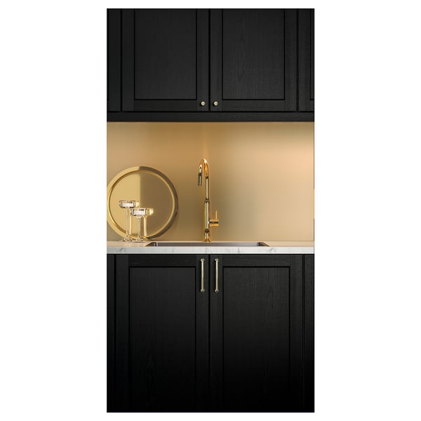 Modern black kitchen setup with gold sink, tap, and backsplash. Sleek, dark cabinets with gold handles.