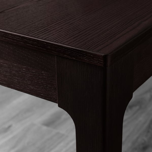 Dark wood table corner, smooth finish, intricate grain detail visible.