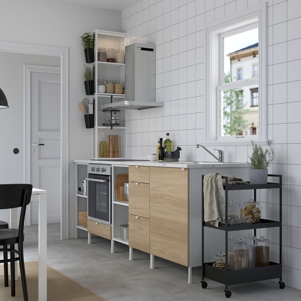 Modern kitchen with ENHET cabinets, steel appliances, open shelves, large window.