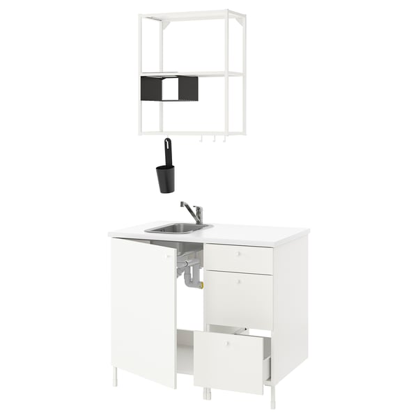 Modern white kitchen setup with stainless steel sink, chrome tap, black container, and open shelving.