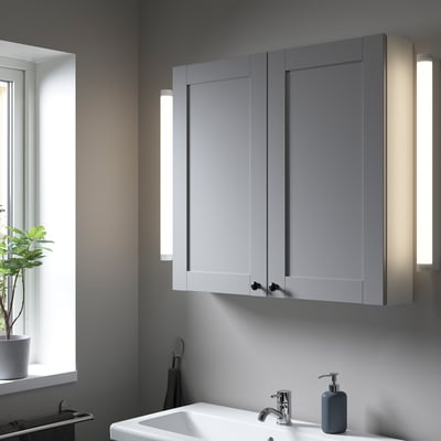 Modern grey ENHET wall cabinet above sink. Two doors, integrated lighting.