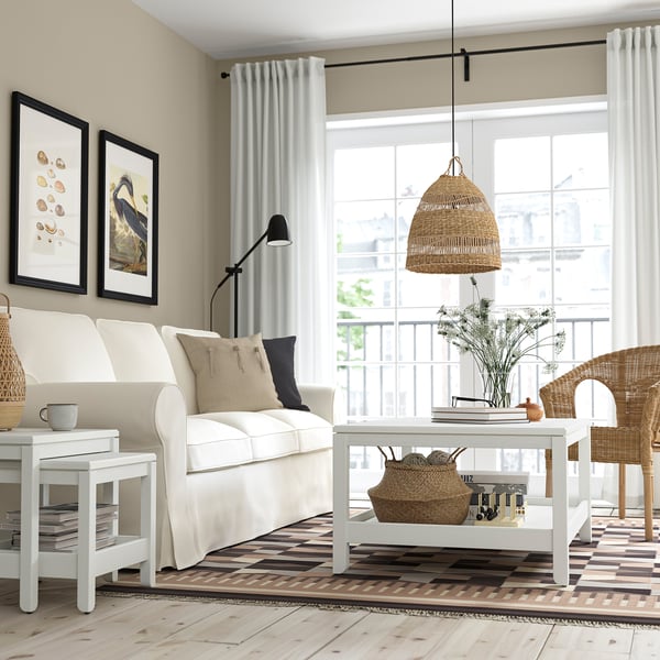 Cosy living room with HAVSTA coffee table, sofa, wicker chair, and cabinet. Generous tabletop & storage. Natural light highlights clean design.